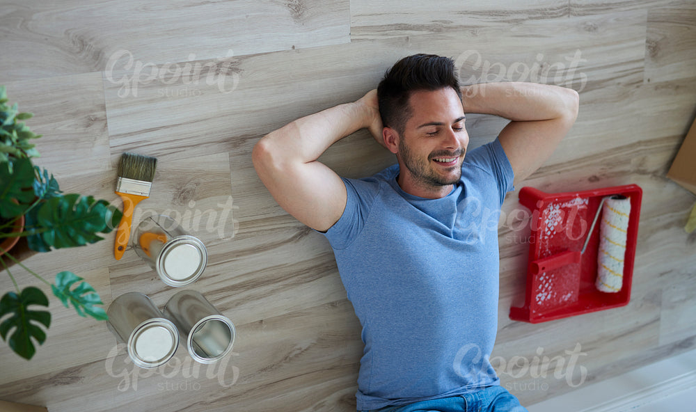 Smiling man taking a short break during painting his flat