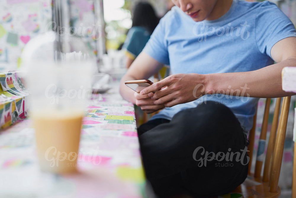 Young man with cell phone in a cafe