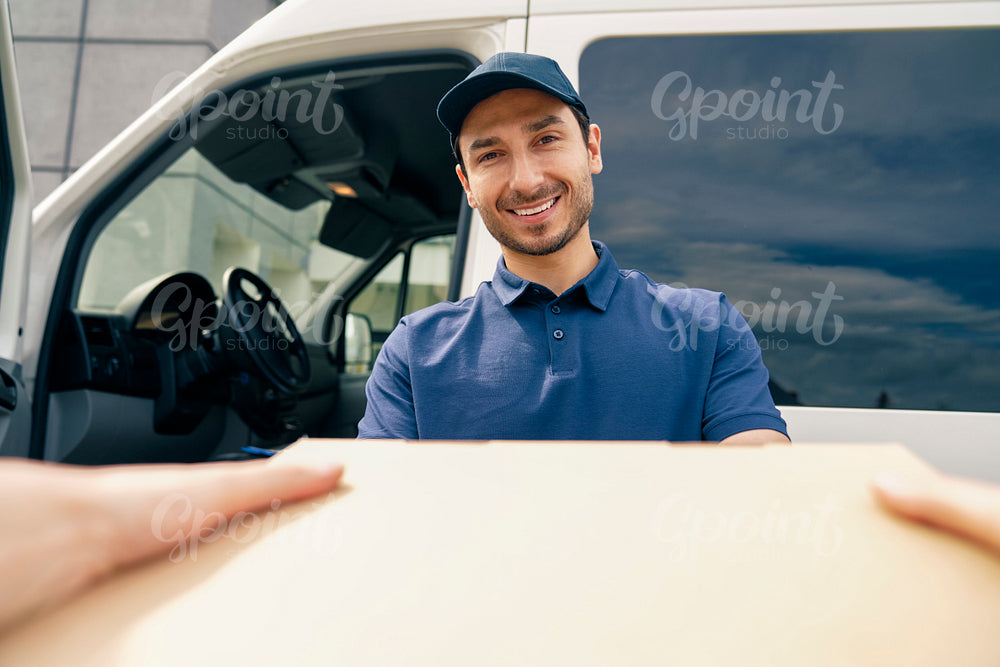 Close up of smiling courier giving a package
