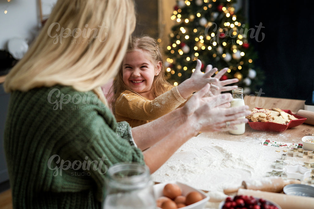 Mother and daughter have fun with flour during Christmas baking