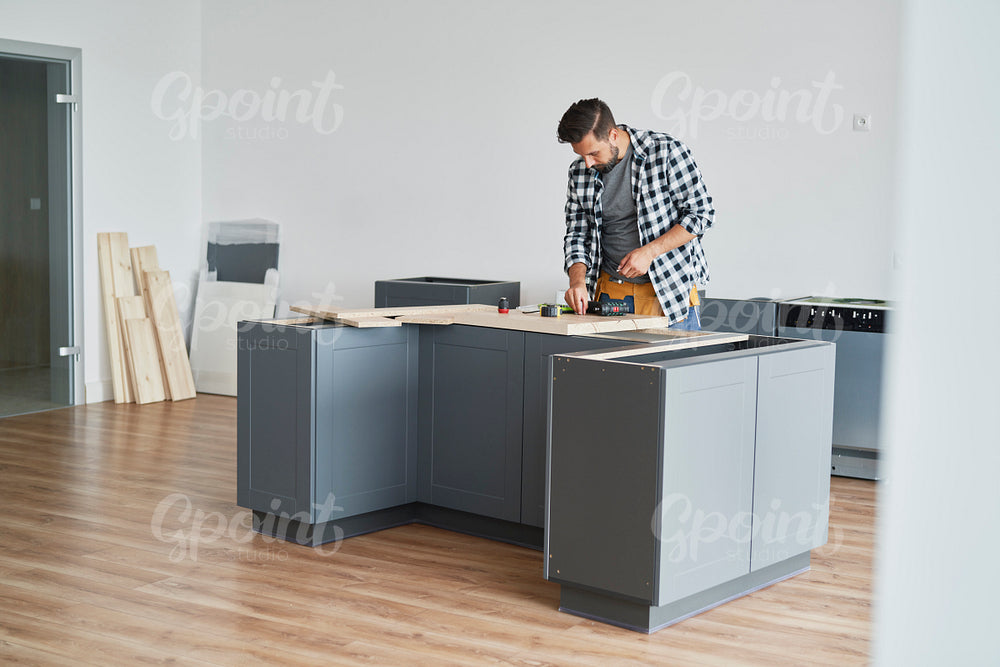 Carpenter installing new kitchen furniture