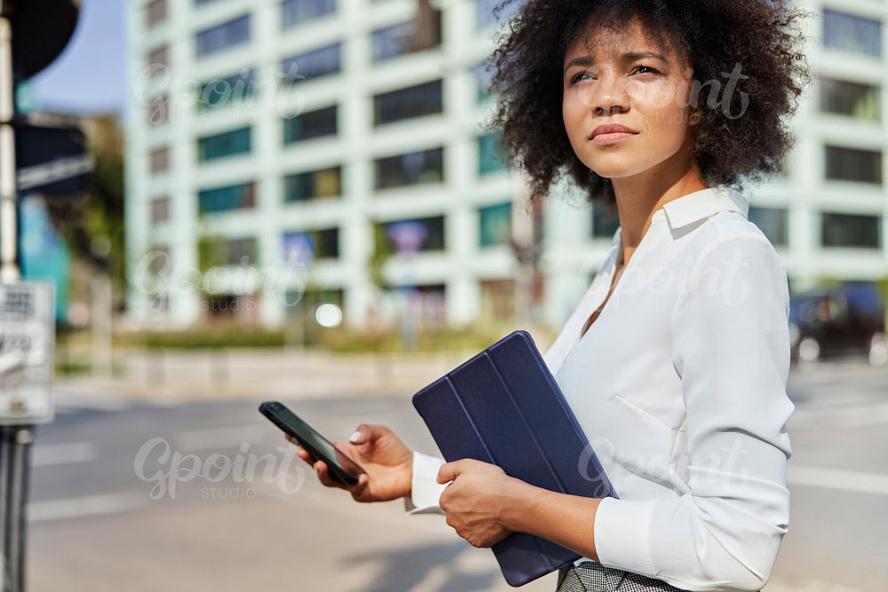 Busy businesswoman with digital tablet and phone outdoors