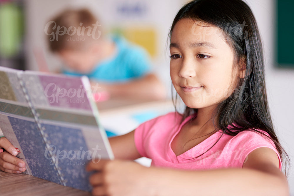 Close up of mixed race girl reading book