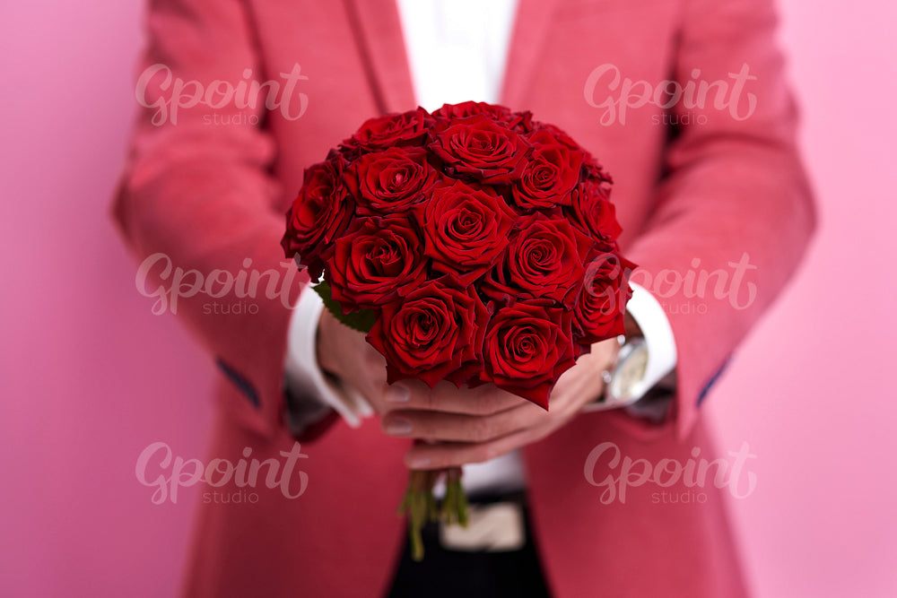 Unrecognizable man giving bunch of rose