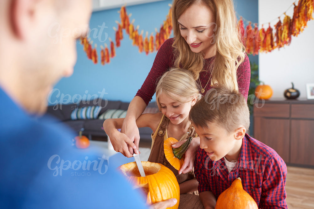 Family working on Halloween pumpkins