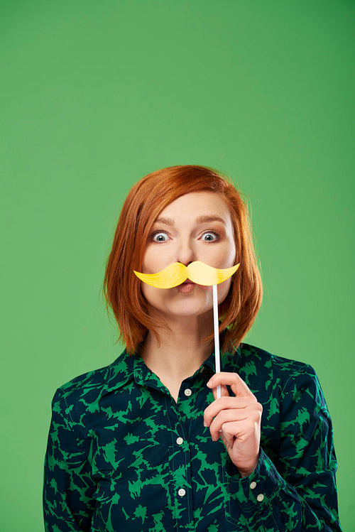 Portrait of playful woman with mustache in studio shot