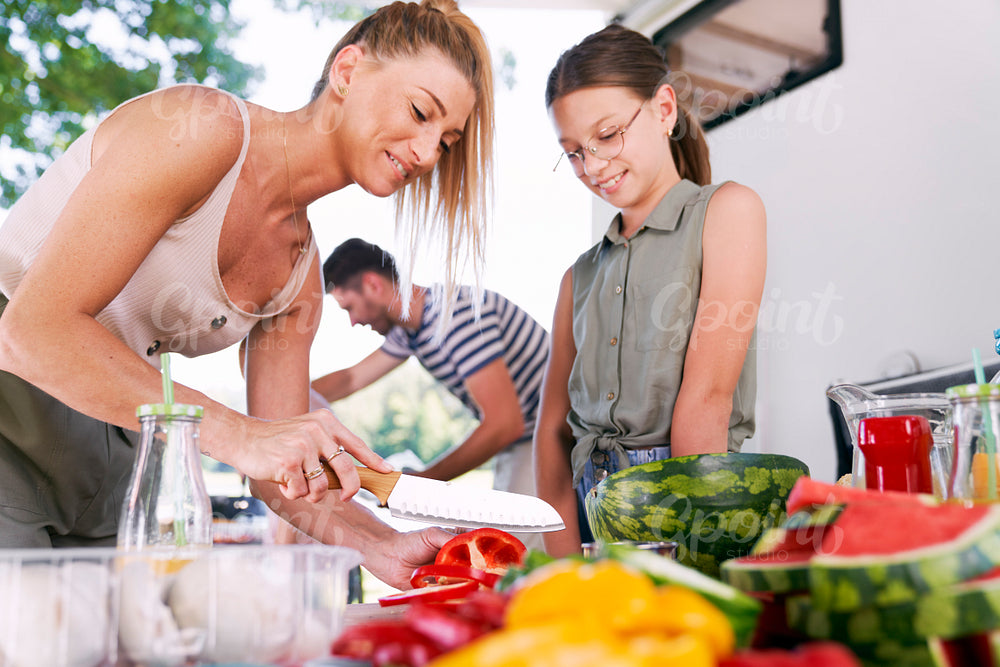 Mother and daughter preparing food for picnic