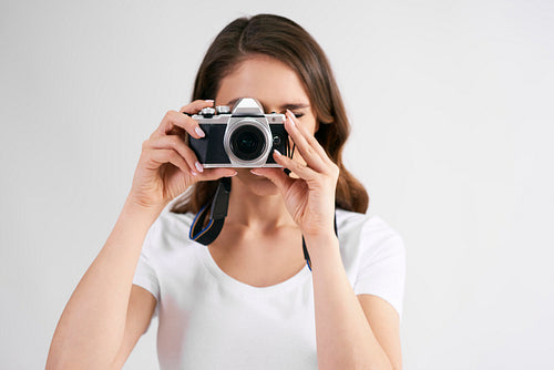 Female photographer with camera photographing in studio shot