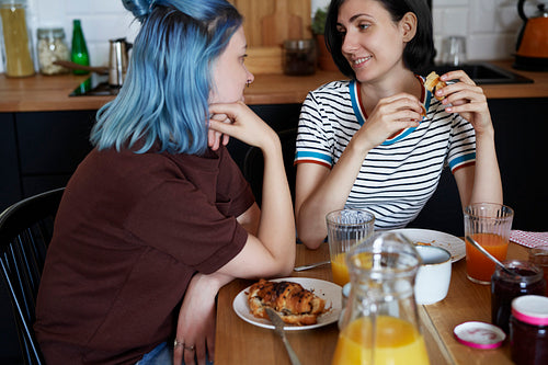 Lesbian couple staring at each other while breakfast