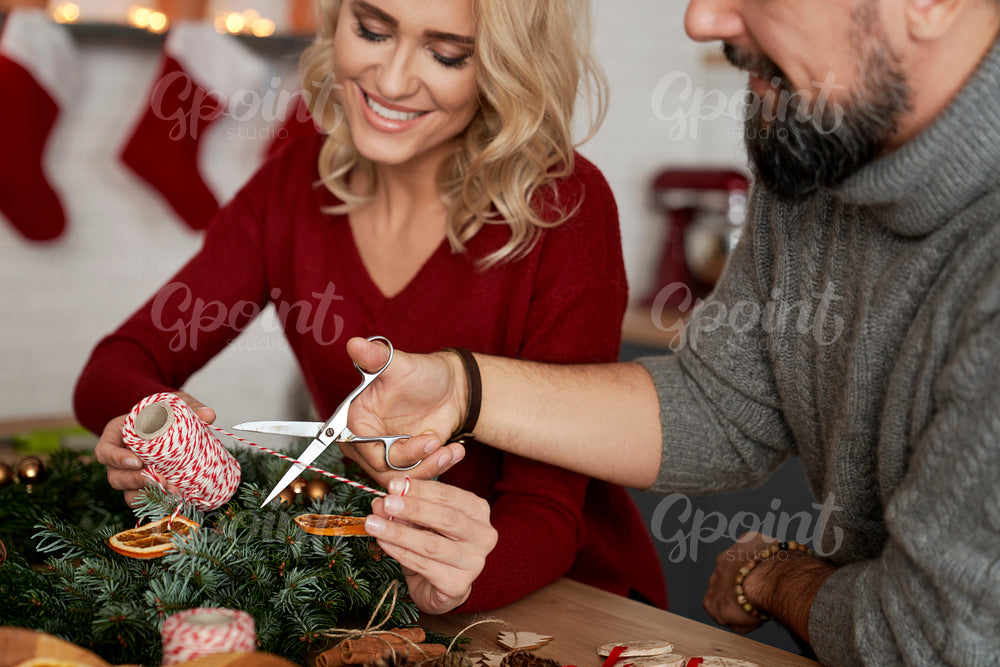 Happy couple preparing a wreath together for Christmas