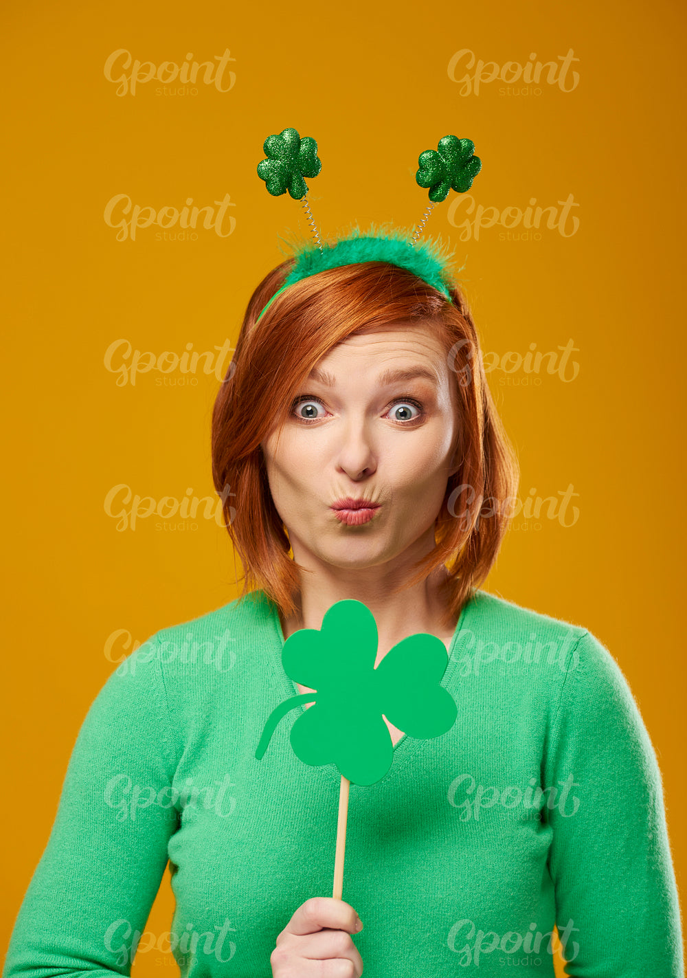 Portrait of woman with clover shaped banner blowing a kiss