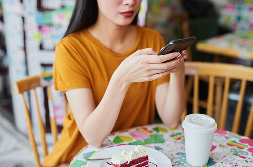 Close up of young woman with cell phone at cafe