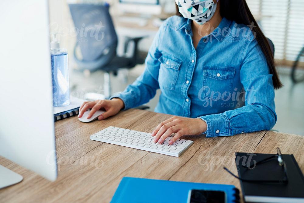 Unrecognizable person in face mask working in the office