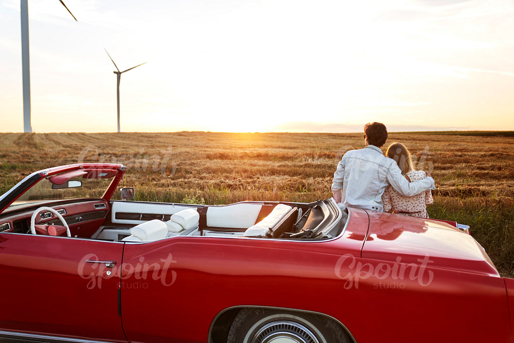 Rear view of couple hugging on a date at sunset