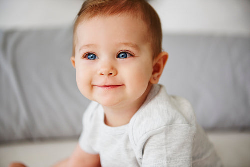 Close up of charming baby sitting on bed
