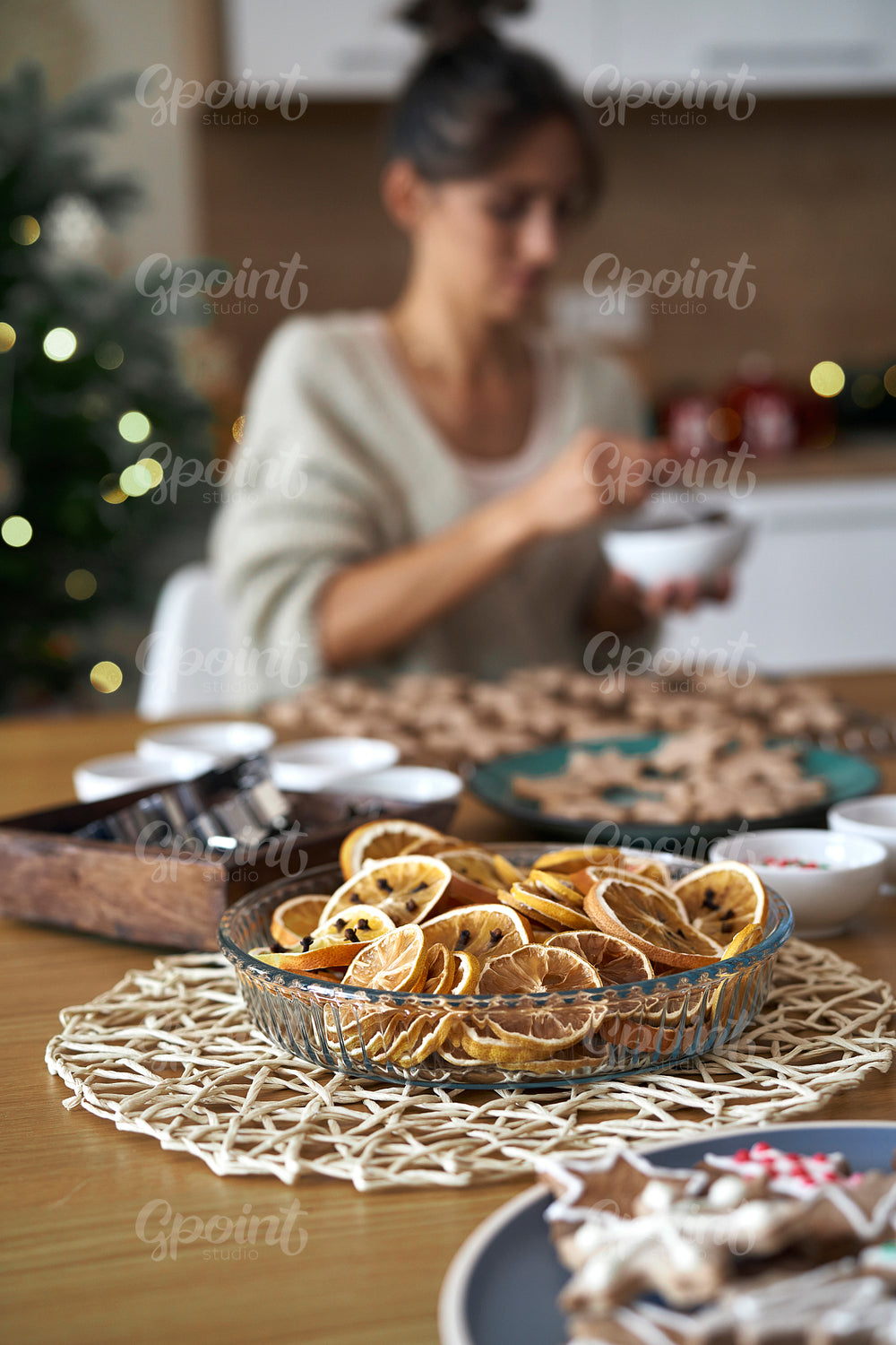 Christmas decorations at the table with woman in background at home