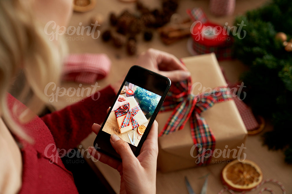 Top view of woman taking photos of the Christmas present