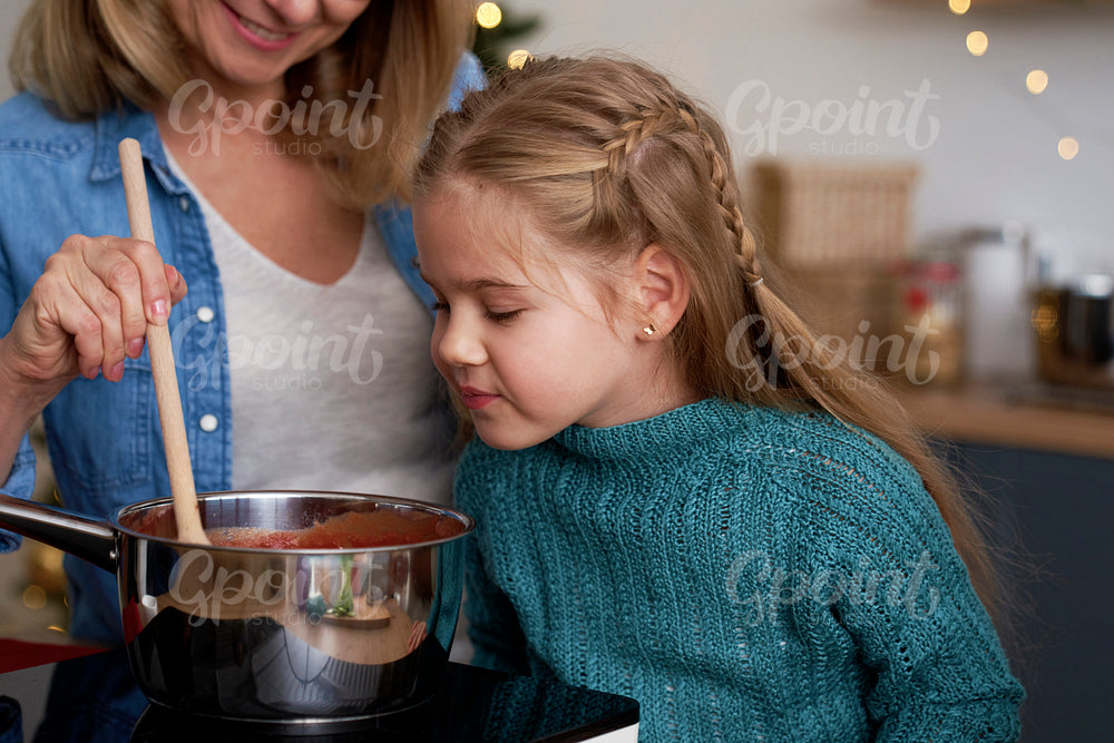 Close up of little girl in the kitchen with grandma