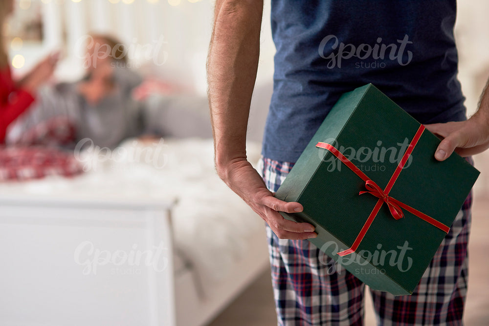 Rear view of man holding gift behind his back