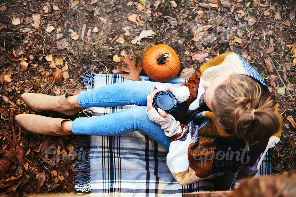 High angle view of woman with coffee relaxing in autumn forest