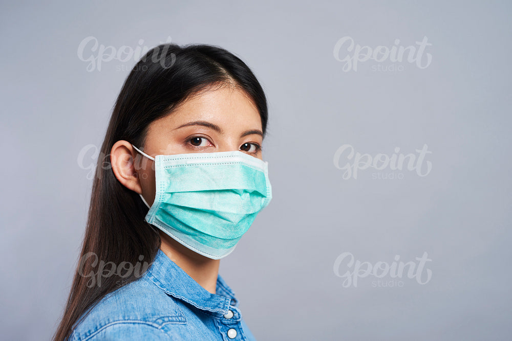 Asian woman in protective mask looking at camera