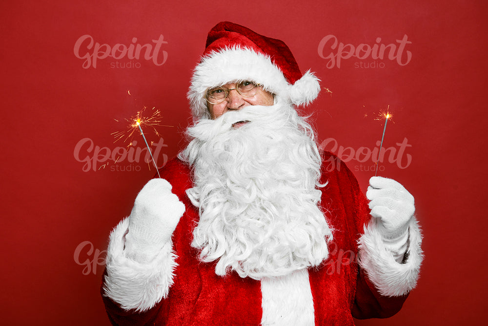 Caucasian Santa Claus holding Christmas sparklers 