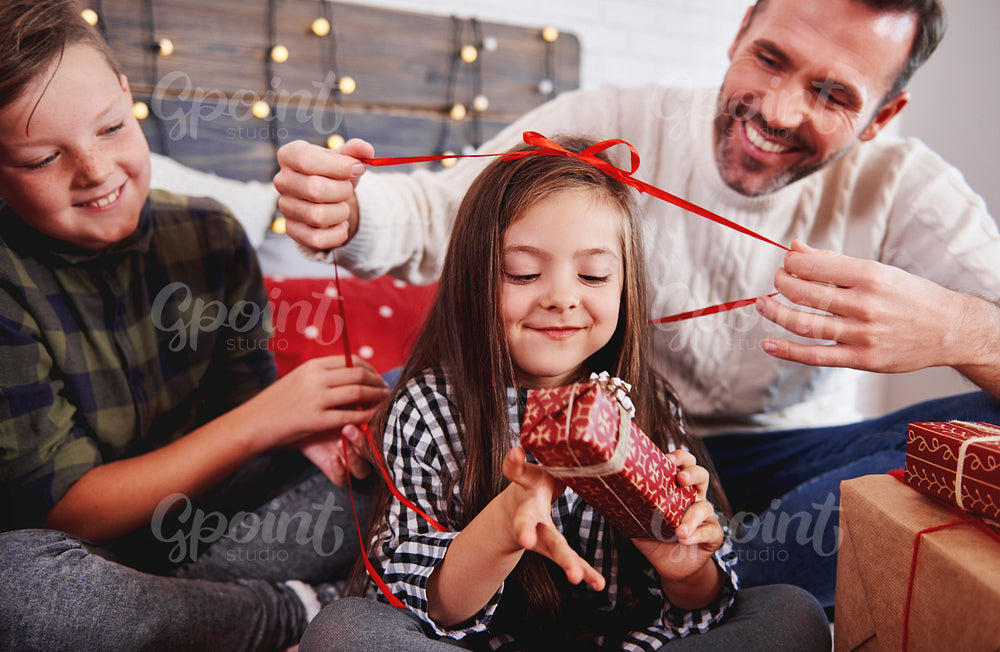 Girl with her family opening christmas present