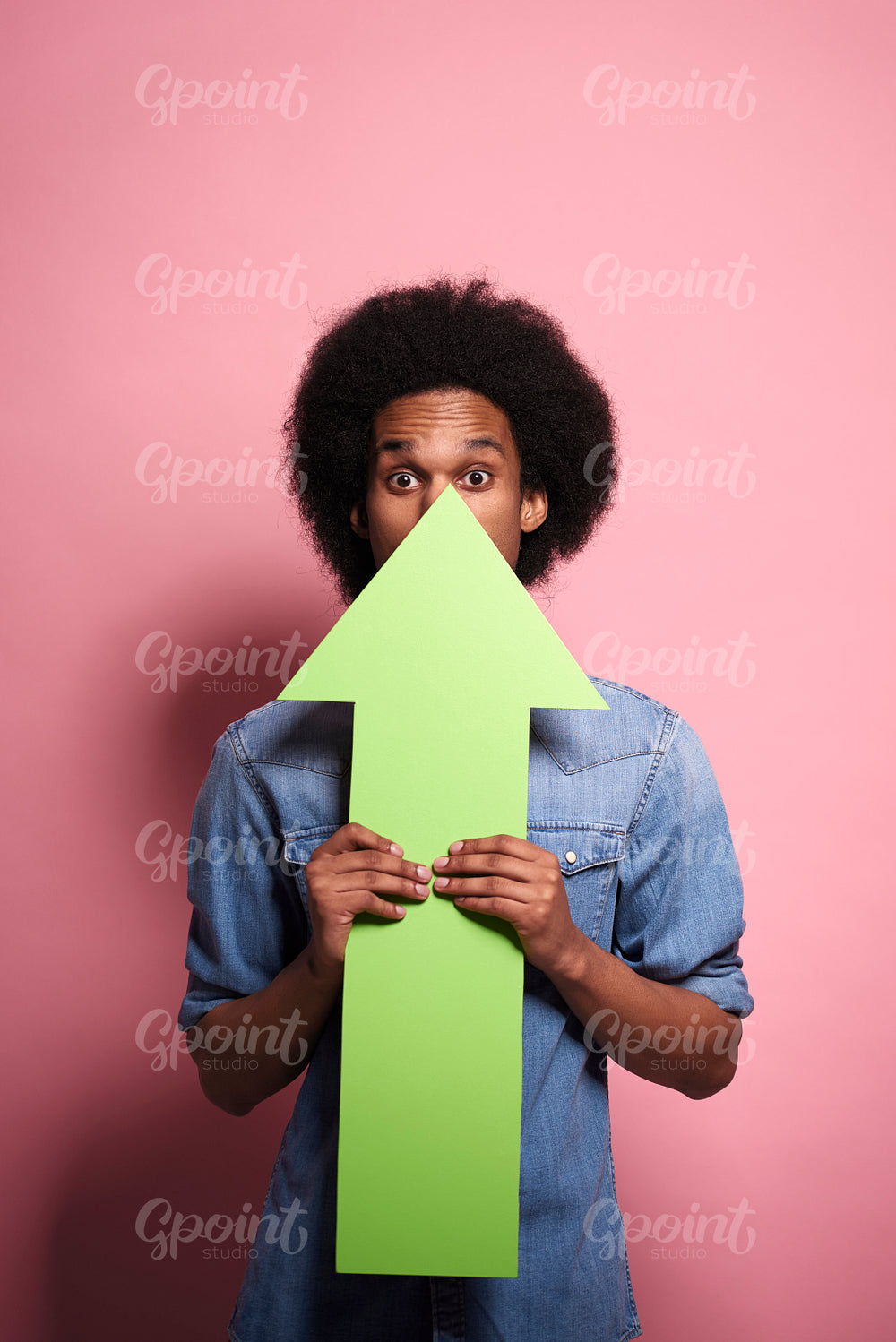 Young African man holding arrow in a studio shot.