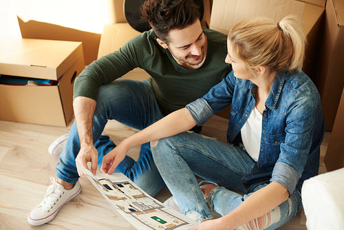Couple sitting on the floor with blueprint