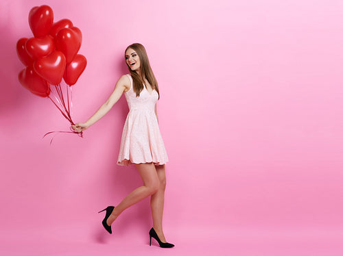 Woman pulling bunch of balloons