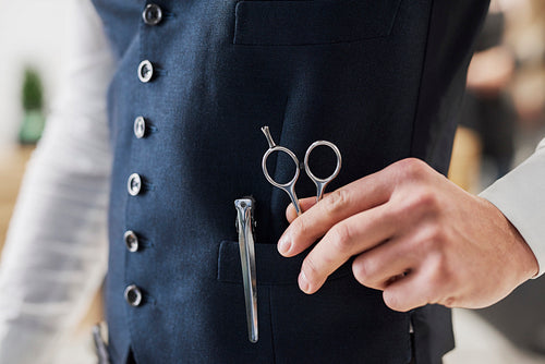 Close up of hairdresser holding professional scissors