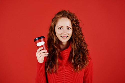 Portrait of smiling girl holding disposable mug of coffee
