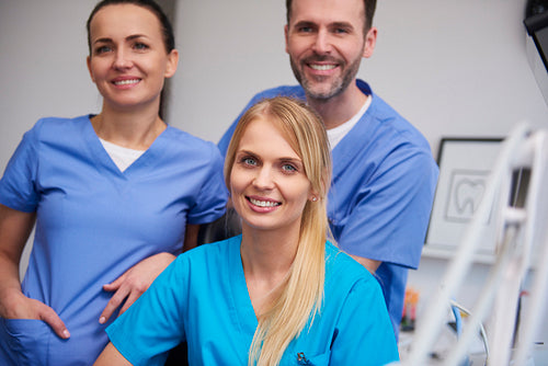 Team of smiling and satisfied dentists in dentist's office