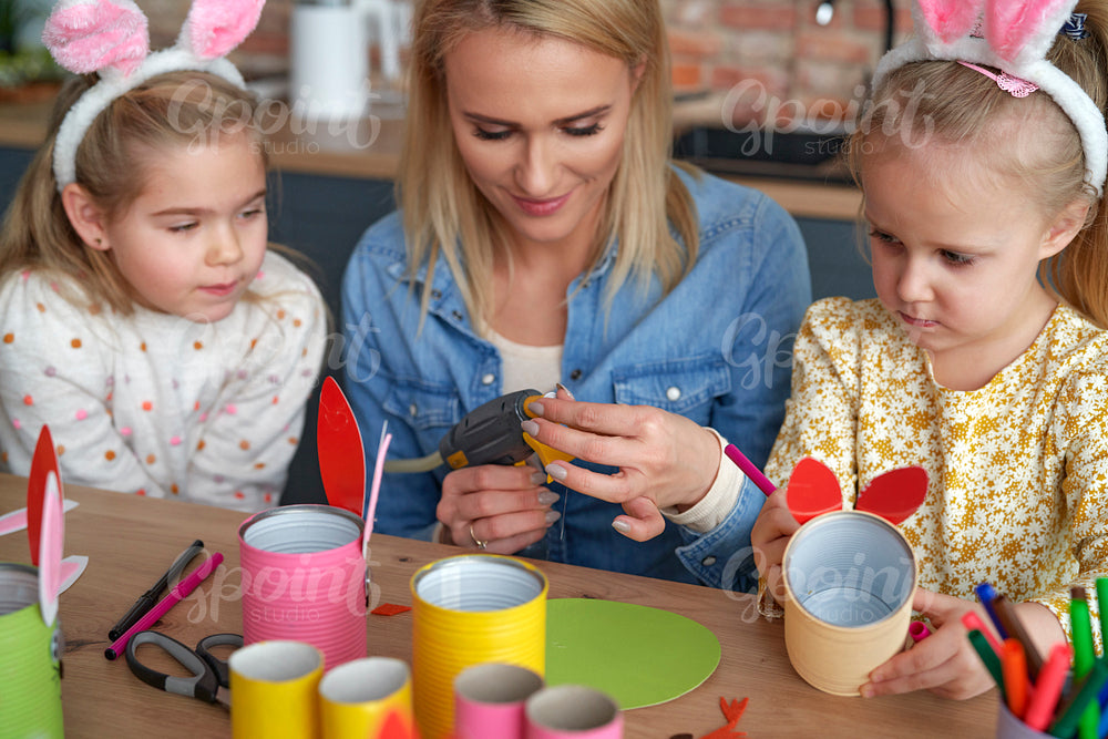 Close up of mom with two girls preparing Easter decorations