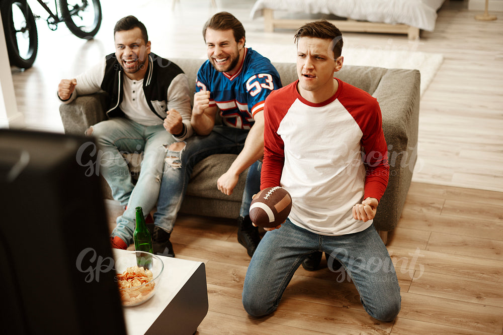 Male friends watching American football