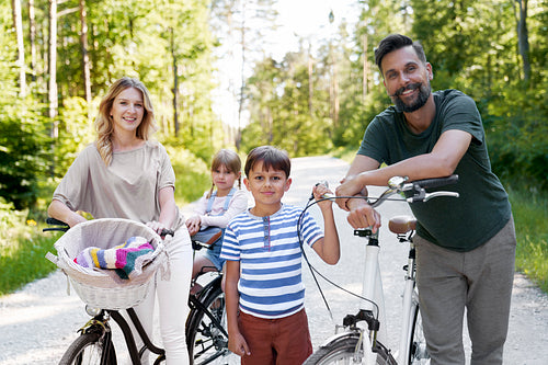 Portrait of smiling family while bike ride in rural landscape