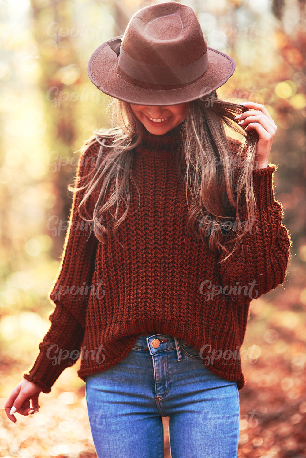 Young woman in a hat in the autumn forest