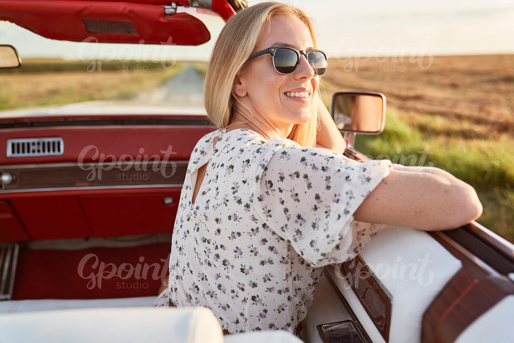 Happy beautiful woman sitting in the car