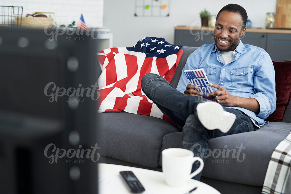 Cheerful man browsing leaflet of USA election