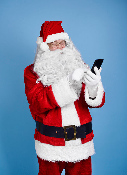 Santa claus using mobile phone at studio shot