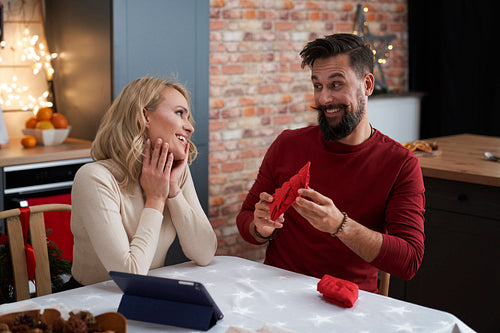 Happy couple spending time together folding Christmas napkins