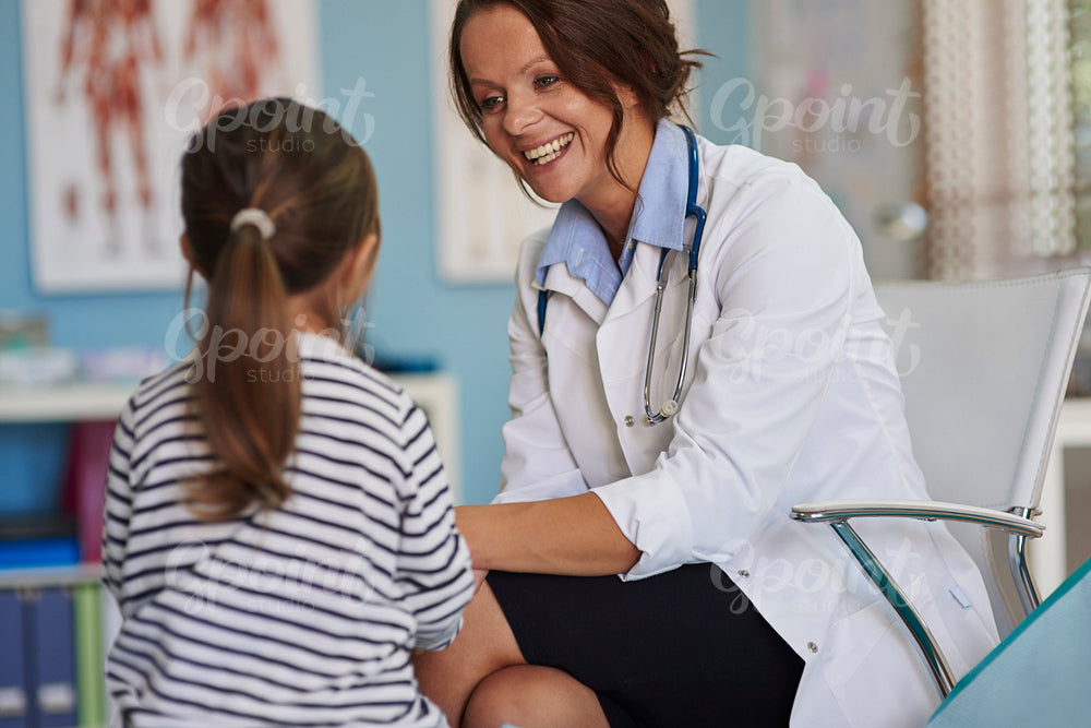 Woman doctor talking to her little patient