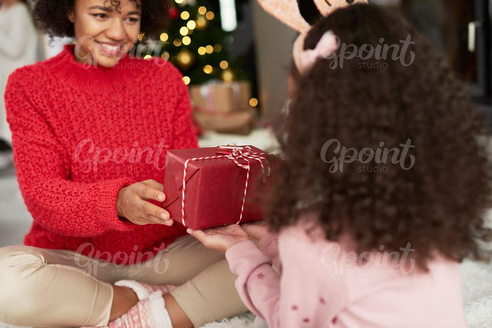 African girl giving mom the Christmas gift