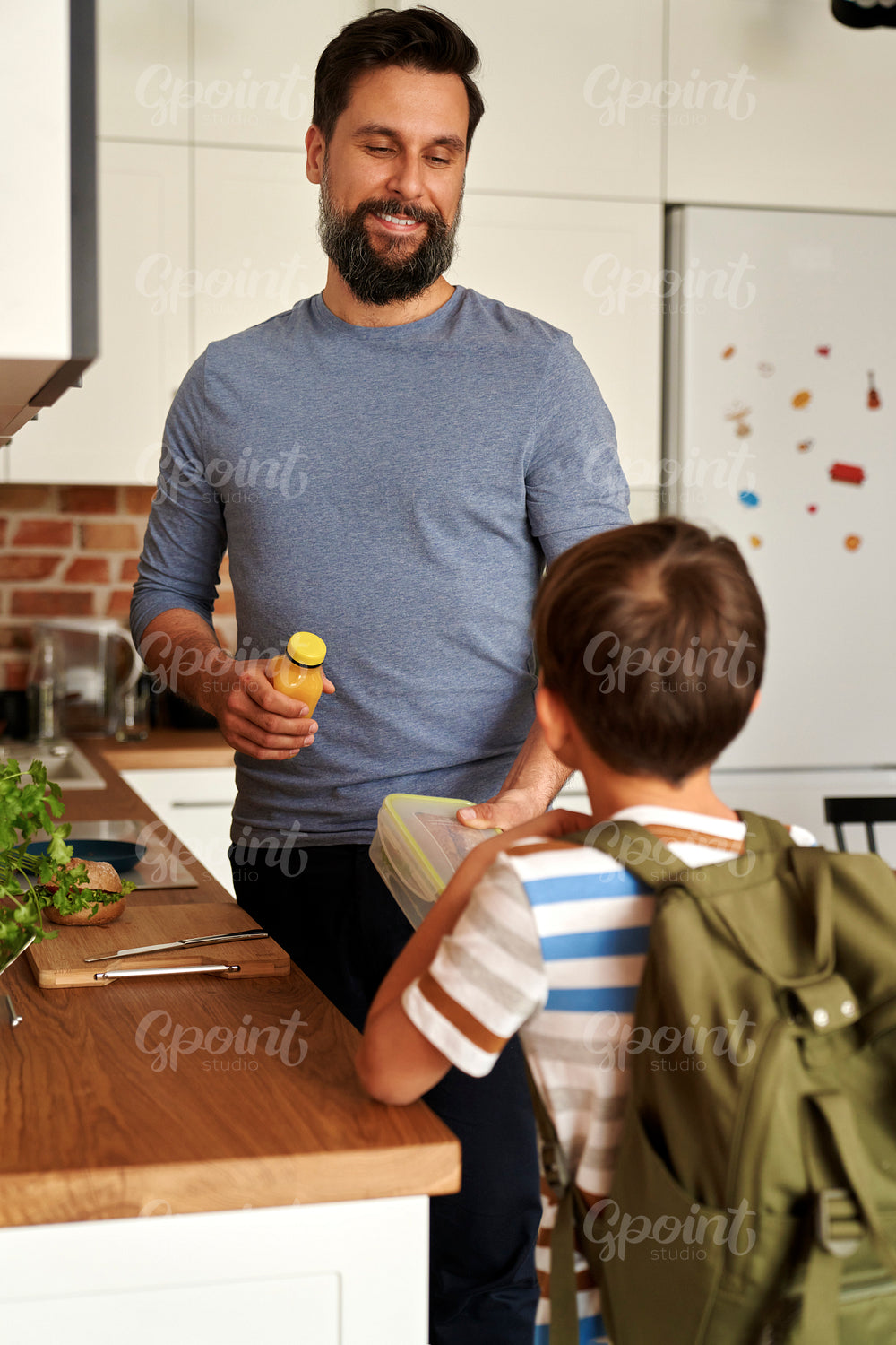 Father giving his son lunch box with healthy food