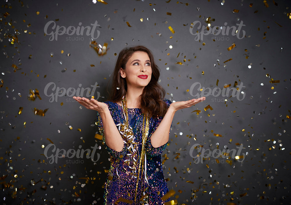 Woman showing something on her hand under shower of confetti