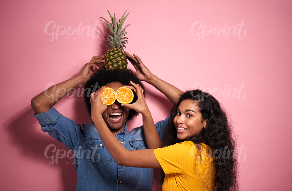 Young African couple having fun with exotic fruits.