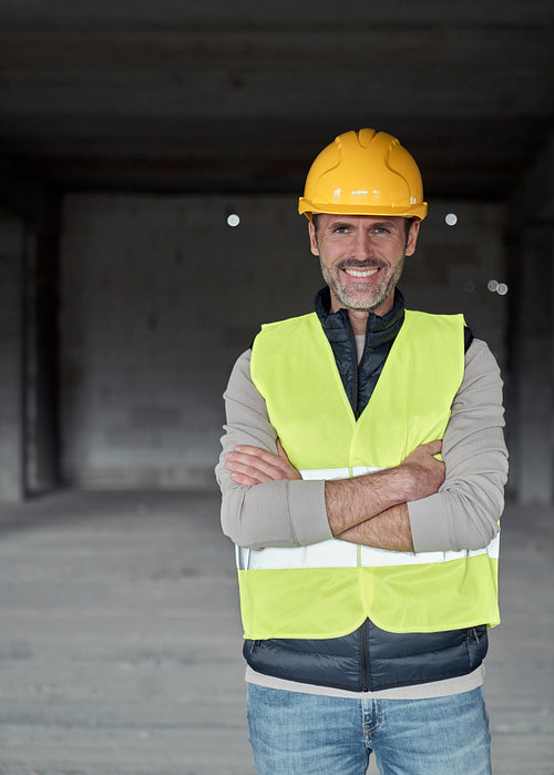 Vertical portrait of caucasian engineer standing on construction site