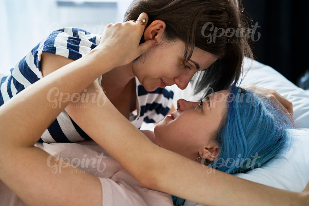 Close up of lesbian couple cuddling intimately in bed