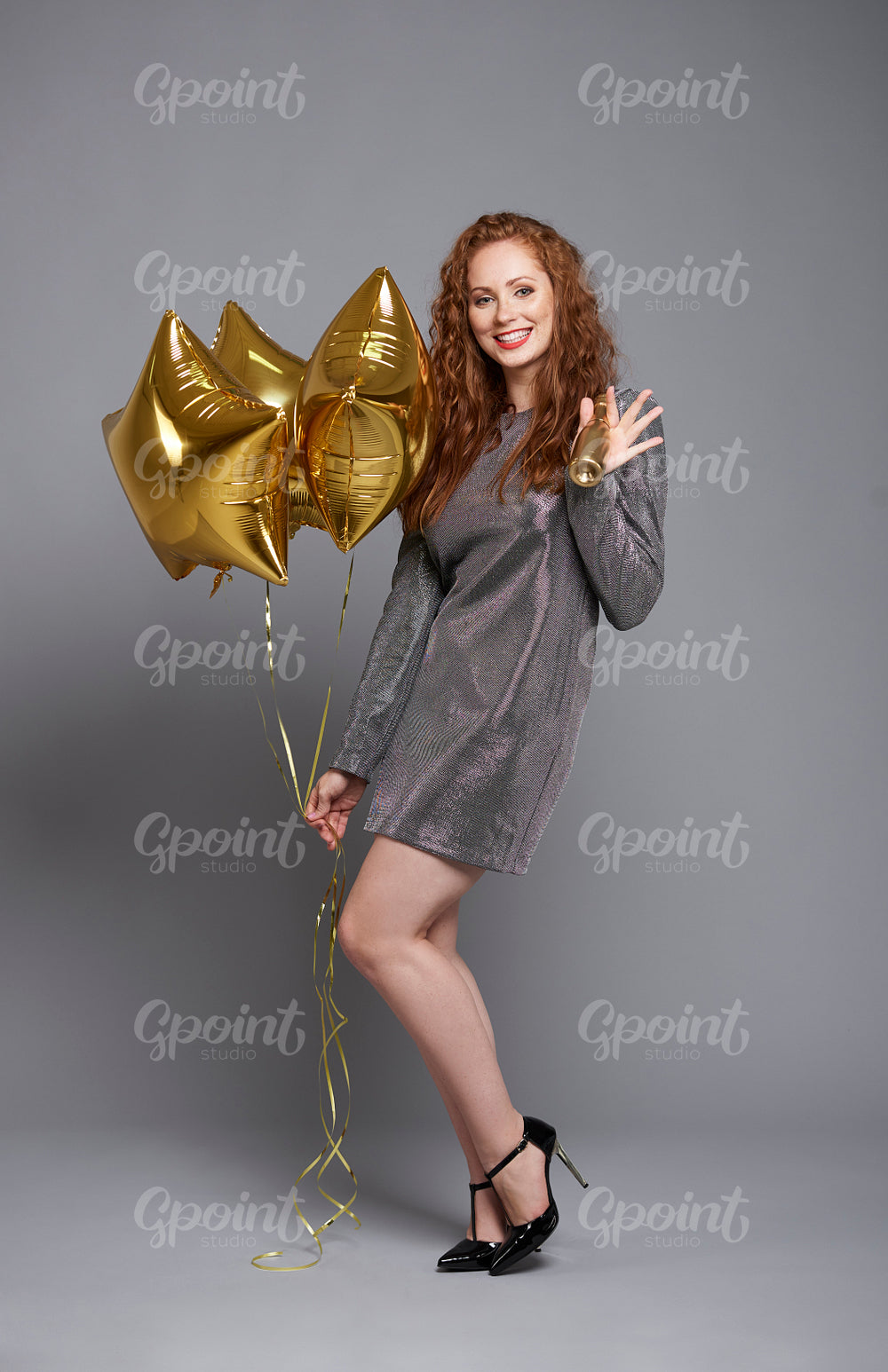 Portrait of woman with balloons and champagne at studio shot
