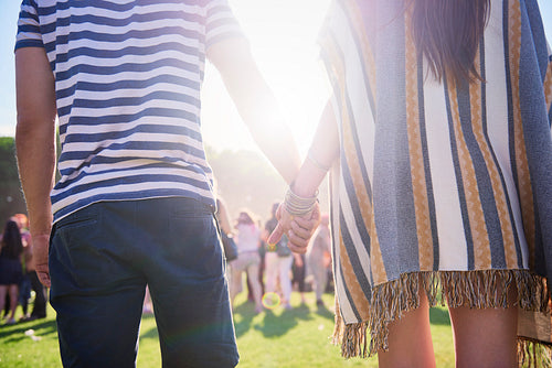 Rear view of couple holding hands in festival